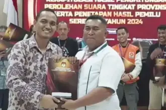 Risvirenol (kanan) saat masih menjabat sebagai Ketua KPU Sulteng menyerahkan Model D hasil tingkat provinsi kepada Ketua Bawaslu Sulteng Nasrun (kiri). (©Humas KPU Sulteng)
