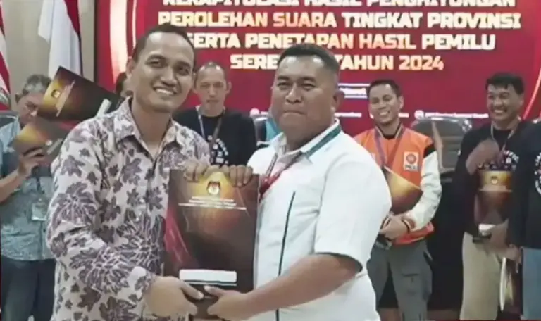 Risvirenol (kanan) saat masih menjabat sebagai Ketua KPU Sulteng menyerahkan Model D hasil tingkat provinsi kepada Ketua Bawaslu Sulteng Nasrun (kiri). (©Humas KPU Sulteng)