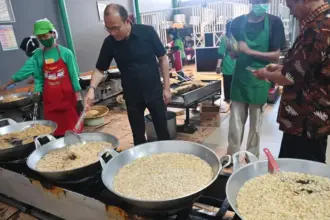 Deputi Bidang Usaha Mikro Kementerian UMKM Muhammad Riza Adha Damanik menggoreng bawang goreng di sentra bawang boreng Mbok Sri di Palu, Senin (22/9/2025). (©bmzIMAGES/basri marzuki)