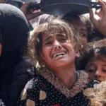 Seorang gadis Palestina berkumpul untuk menerima makanan yang dimasak oleh dapur amal, di Khan Younis, Jalur Gaza selatan, Palestina, 29 April 2025. (©Reuters/dailysabah.com)