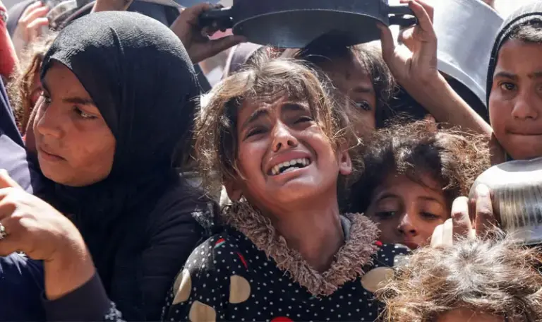 Seorang gadis Palestina berkumpul untuk menerima makanan yang dimasak oleh dapur amal, di Khan Younis, Jalur Gaza selatan, Palestina, 29 April 2025. (©Reuters/dailysabah.com)