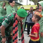 Seorang anak membisikkan sesuatu kepada Pangdam XXIII/Palaka Wira setibanya di Markas Yonif 714/Sintuwu Maroso, Poso, Selasa (23/9/2025). (©Pendam 23/PW)