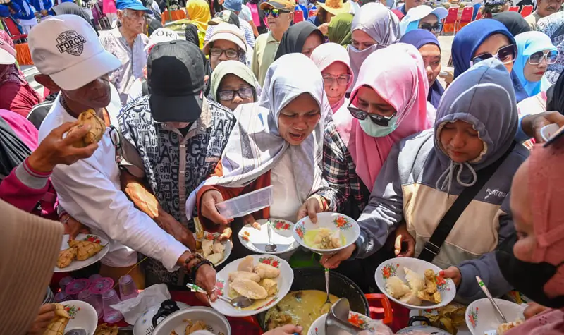 Warga mencicipi utadada yang disajikan pad aFestival Utadada di RTH Asmaul Husna, Bing=angga, Sigi, Sabtu (20/9/2025). (©bmzIMAGES/basri marzuki)