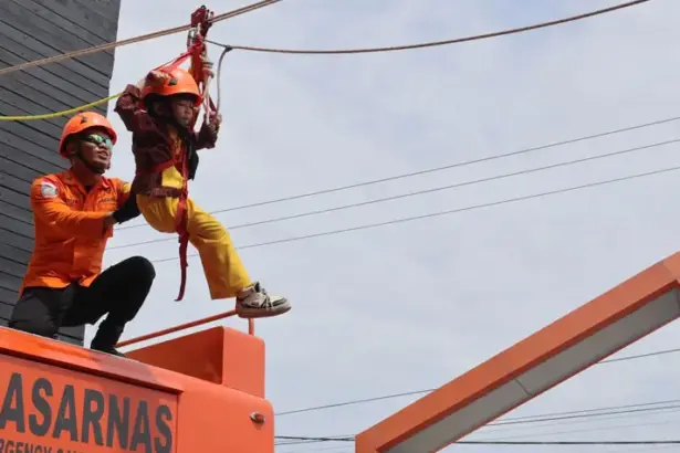 Seorang murid TK mencoba menggunakan Vertical Rescue/High Angle Rescue saat mengunjungi Kantor SAR Palu dalam rangka pendidikan dini mitigasi bencana, Selasa (30/9/2025). (© Bsaarnas Palu)