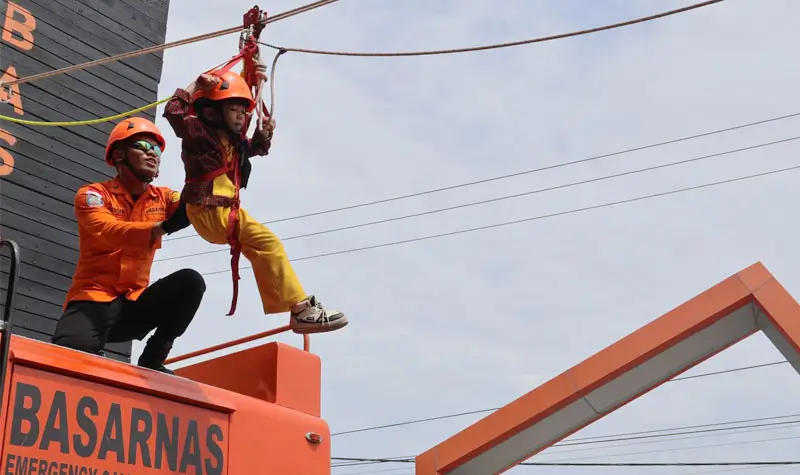 Seorang murid TK mencoba menggunakan Vertical Rescue/High Angle Rescue saat mengunjungi Kantor SAR Palu dalam rangka pendidikan dini mitigasi bencana, Selasa (30/9/2025). (© Bsaarnas Palu)
