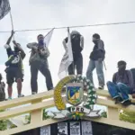 Sejumlah mahasiswa berada di atas pagar kantor DPRD Sutleng saat aksi unjuk rasa, Senin (1/9/2025). (©bmzIMAGES/basri marzuki)