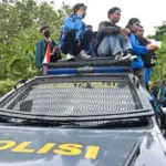 Sejumlah mahasiswa duduk di atas kendaraan penerangan polisi pada unjuk rasa damai di depan kantor DPRD Sulteng, Senin (1/9/2025). (©bmzIMAGES/basri marzuki)