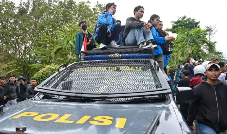 Sejumlah mahasiswa duduk di atas kendaraan penerangan polisi pada unjuk rasa damai di depan kantor DPRD Sulteng, Senin (1/9/2025). (©bmzIMAGES/basri marzuki)