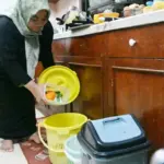 Rina memasukkan sampah organik ke dalam ember di rumahnya di kawasan perumahan karyawan PT Vale Indonesia di Pontada, Sorowako, Luwu Timur, Sulsel, Sabtu (26/7/2025). (© bmzIMAGES/basri marzuki)