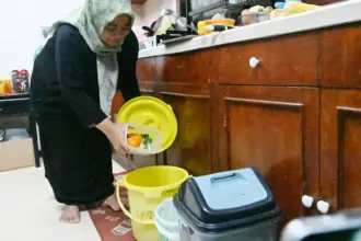 Rina memasukkan sampah organik ke dalam ember di rumahnya di kawasan perumahan karyawan PT Vale Indonesia di Pontada, Sorowako, Luwu Timur, Sulsel, Sabtu (26/7/2025). (© bmzIMAGES/basri marzuki)