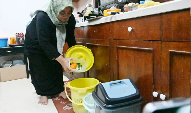 Rina memasukkan sampah organik ke dalam ember di rumahnya di kawasan perumahan karyawan PT Vale Indonesia di Pontada, Sorowako, Luwu Timur, Sulsel, Sabtu (26/7/2025). (© bmzIMAGES/basri marzuki)