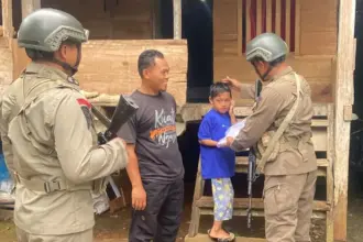 Personel Madago raya membagikan perlengkapan sekolah kepada anak dalam ekgiatan sambang di Poso, Kamis (11/9/2025). (©Humas Satgas Madago raya)