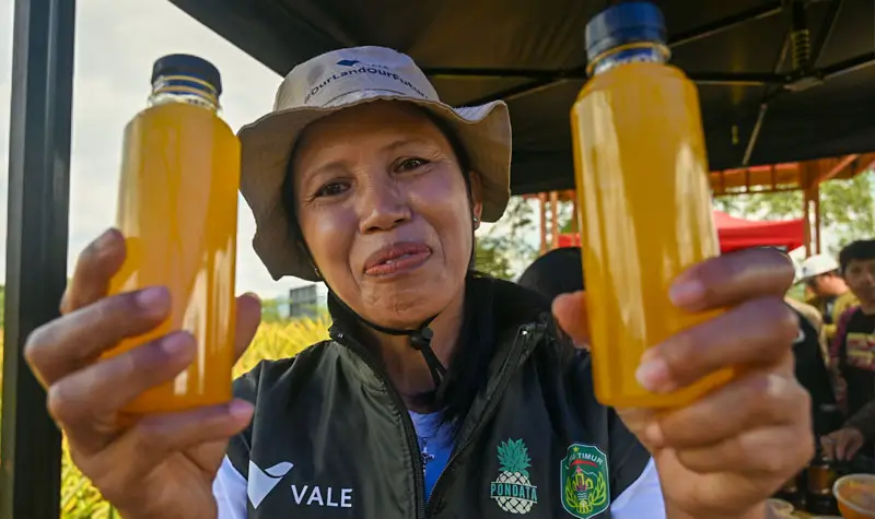 Anggota kelompok tani menunjukkan jus nenas hasil olahan dari perkebunan desa di Desa Tabarano, Kecamatan Wasuponda, Luwu Timur, Sulawesi Selatan, Minggu (27/7/2025). (©bmzIMAGES/basri marzuki)
