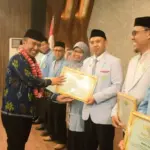 Plt. Asisten bidang Perekonomian dan Pembangunan Setda Kota Palu, Rahmad Mustafa menyerahkan piagam pada rangkaian pelantikan dan rakerda BKPRMI Kota Palu, Sabtu (20/9/2025). (©Prokopim Setda Kota PAlu/Imron)