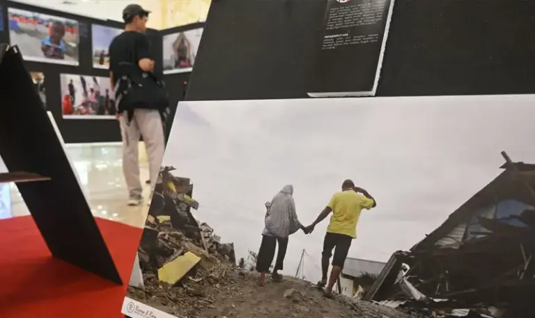 Sejumlah pengunjung memperhatikan foto bencana bertema "Asa di Atas Patahan" pada pameran yang dinisiasi PFI Palu di PGM Palu, Senin (15/9/2025). Pameran yang digelar hingga 17 September 2025 itu menampilkan 60 foto dari 25 fotografer baik dalam maupun luar negeri untuk mengenang tujuh tahun bencana gempa, tsunami dan likuifaksi di Palu, Sigi, dan Donggala September 2018 silam. (©bmzIMAGES/basri marzuki)