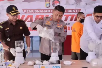 Kapolres Morowali AKBP Zulkarnain (tengah) menuangkan sabu ke dalam belneder pada pemusnahan di mapolres Morowali, Senin (22/9/2025). (©Humas Polres Morowali)