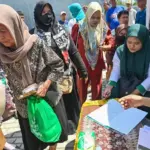 Warga menerima paket bantuan yang disalurkan Baznas Kota Palu di Kecamatan Palu barat, Selasa (14/10/2025). (© bmzIMAGES/Basri Marzuki)