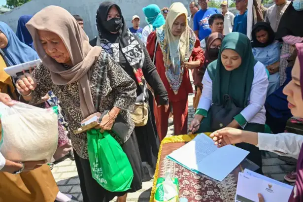 Warga menerima paket bantuan yang disalurkan Baznas Kota Palu di Kecamatan Palu barat, Selasa (14/10/2025). (© bmzIMAGES/Basri Marzuki)