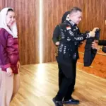 Wali Kota Palu Hadianto Rasyid memasangkan rompi menandai peluncuran Sekolha Khusus Keluarga di Ruang Auditorium Kantor Wali Kota Palu, Kamis (16/10/2025). (© Prokopim Setda Kota Palu/Yuspi)