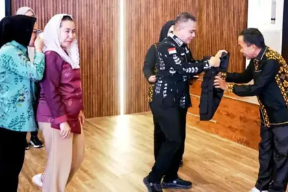 Wali Kota Palu Hadianto Rasyid memasangkan rompi menandai peluncuran Sekolha Khusus Keluarga di Ruang Auditorium Kantor Wali Kota Palu, Kamis (16/10/2025). (© Prokopim Setda Kota Palu/Yuspi)