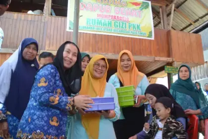 Wakil Wali Kota Palu, Imelda Liliana Muhidin menyerahkan makanan tambahan kepada anak pada peluncuran Dapur Sehat Mompakabelo Rumah Gizi PKK Kelurahan Lolu Utara, Kecamatan Palu Timur, Rabu (1/10/2025). (© Prokopim Setda Kota Palu/Imron)