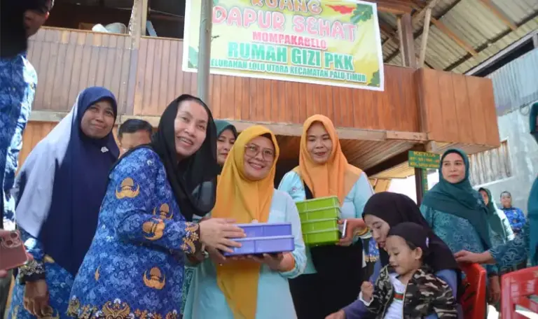 Wakil Wali Kota Palu, Imelda Liliana Muhidin menyerahkan makanan tambahan kepada anak pada peluncuran Dapur Sehat Mompakabelo Rumah Gizi PKK Kelurahan Lolu Utara, Kecamatan Palu Timur, Rabu (1/10/2025). (© Prokopim Setda Kota Palu/Imron)