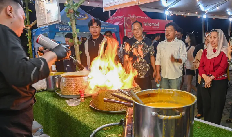 Wawali Imelda (kiri) menyaksikan pramu saji menyiapkan makanan pesanan pembeli pada Festival Kuliner Palu Raasa Bangkok di PGM Palu, Rabu (1/10/2025) malam. (© Prokopim Setda Kota palu/Jufri)