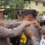 Kapolresta Palu Kombes Pol Deny Abrahams menyematkan bet menandai peresmian program Pamapta Polresta Palu, Senin (27/10/2025). (©Humas Polresta Palu)