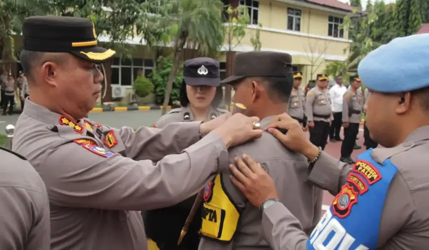 Kapolresta Palu Kombes Pol Deny Abrahams menyematkan bet menandai peresmian program Pamapta Polresta Palu, Senin (27/10/2025). (©Humas Polresta Palu)