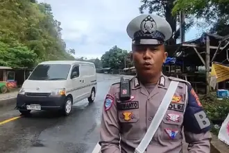 Anggota Polantas Polres Parigi Mutong, Bripka Siswanto melaporkan berakhirnya sistem buka-tutup jalan di ruas Kebun Kopi, MInggu (26/10/2025). (©Tangkapan layar video Bripka SIswanto)