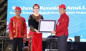 Kakanwil Kemenkum Sulteng, Rakhmat Rinaldy (kanan) menyerahkan sertifikat KIK kepada Bupati Poso Ver GM Inkiriwang pad apembukaan Festival Danau Poso di Poso, Kamis (24/10/2025). (©Kemenkum Sulteng)