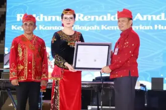 Kakanwil Kemenkum Sulteng, Rakhmat Rinaldy (kanan) menyerahkan sertifikat KIK kepada Bupati Poso Ver GM Inkiriwang pad apembukaan Festival Danau Poso di Poso, Kamis (24/10/2025). (©Kemenkum Sulteng)