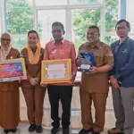 Lurah Tanamodindi (tengah) menunjukkan piagam penghargaan setelah meraih predikat terbaik Kelurahan Cantik se Sulteng dari BPS Sulteng, Senin (13/10/2025). (© bmzIMAGES/Basri Marzuki)
