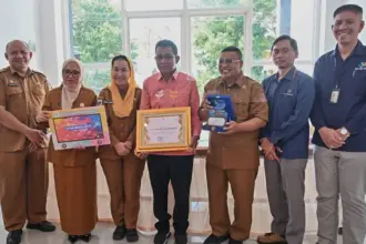 Lurah Tanamodindi (tengah) menunjukkan piagam penghargaan setelah meraih predikat terbaik Kelurahan Cantik se Sulteng dari BPS Sulteng, Senin (13/10/2025). (© bmzIMAGES/Basri Marzuki)