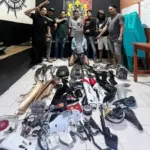 Tersangka kasus curanmor, MJ berlurut di depan barang bukti curnamor di Mapolresta Palu, Senin (7/10/2025). (© Humas Polresta Palu)