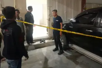 Petugas memasang Police Line di kediaman AS yang diduga dibunuh di Palupi, Minggu (19/10/2025) malam. (© Humas Polresta Palu)