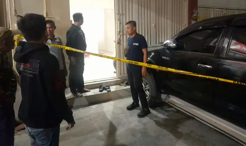 Petugas memasang Police Line di kediaman AS yang diduga dibunuh di Palupi, Minggu (19/10/2025) malam. (© Humas Polresta Palu)