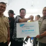 Bupati Luwu Timur Irwan Bachri Syam (kanan) menyerahkan kompensasi dampak kebocoran pipa PT Vale kepada perwakilan warga di Towuti, Luwu Timur, Kamis (2/10/2025). (© PT Vale Indonesia)