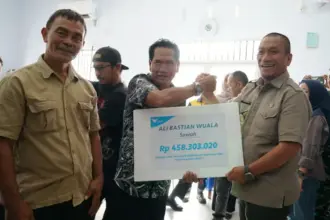 Bupati Luwu Timur Irwan Bachri Syam (kanan) menyerahkan kompensasi dampak kebocoran pipa PT Vale kepada perwakilan warga di Towuti, Luwu Timur, Kamis (2/10/2025). (© PT Vale Indonesia)