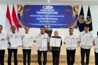 Kakanwil Ditjenpas Sulteng Bagus Kurniawan (keempat kiri) dan Ketua Koperasi Farmtisan Lestari Berjaya Magfirah (keempat kanan) bersama sejumlah UPT Pemasyarakatan menunjukkan naskah PKS usai diteken di Aula Rutan Palu, Kamis (6/11/2025). (©Humas Kanwil Ditjenpas Sulteng)