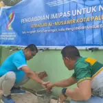 Kakanwil Ditjenas Sulteng memasang keramik di tempat wudhu Masjid Al-Musyawir pada "Pengabdian untuk Negeri" Kemenimipas di Palu, Sabtu (22/11/2025). (©HUmas Ditjenpas Sulteng)