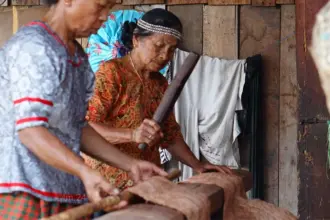 Ina Tobani (kanan) membuat kain dari kulit kayu untuk bertahan hidup dan manjaga warisan budaya. (©Imran)