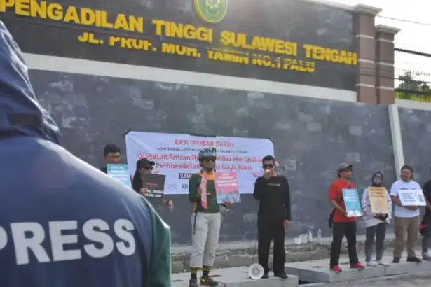 Sejumlah jurnalis membawa pamplet saat menggelar aksi mimbar beas di depan Kantor Pengadilan Tinggi SUlteng, Minggu (16/11/2025). (©KKJ Sulteng)