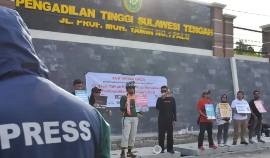 Sejumlah jurnalis membawa pamplet saat menggelar aksi mimbar beas di depan Kantor Pengadilan Tinggi SUlteng, Minggu (16/11/2025). (©KKJ Sulteng)