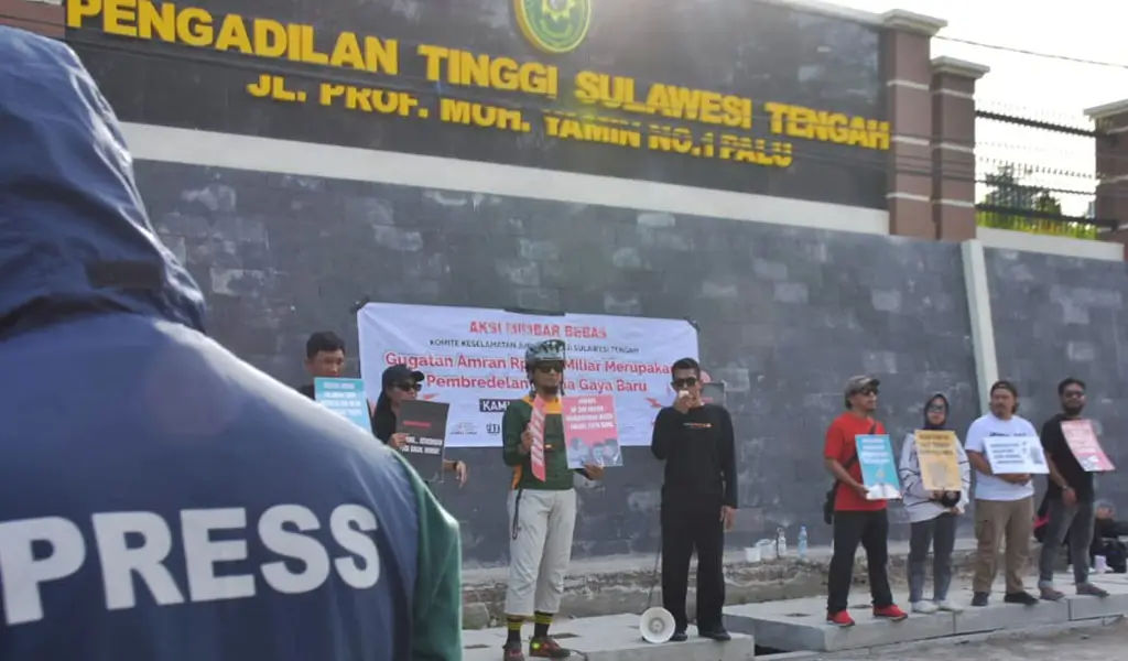 Sejumlah jurnalis membawa pamplet saat menggelar aksi mimbar beas di depan Kantor Pengadilan Tinggi SUlteng, Minggu (16/11/2025). (©KKJ Sulteng)