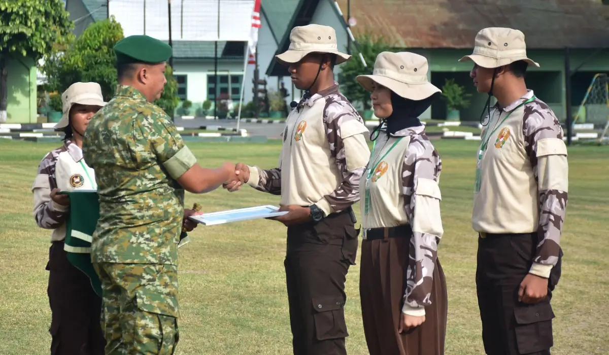 Danem 132/Tadulako, Brigjen TNI Deni Gunawan menyerahkan sertifikat kepad asalah seorang Kadet pada penutupan Persami KKRi di Yonif 711/Raksatama Palu, Minggu (2/11/2025). (©Pendam23)
