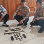 Aparat menata komponen senpi rakitan beserta amunisi yang diserahkan warga Poso Pesisir. (©Huams Polres Poso)