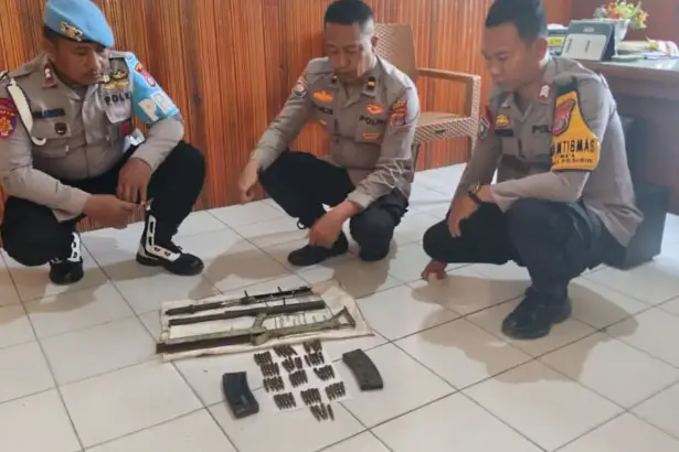 Aparat menata komponen senpi rakitan beserta amunisi yang diserahkan warga Poso Pesisir. (©Huams Polres Poso)