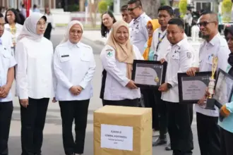 Penyerahaan penghargaan pada peringatan HKN ke-61 di halaman Kantor Wali Kota Palu, Rabu (12/11/2025). (©Prokopim Setda Kota Palu/Jufri)