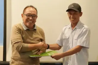 Kadis Kesehatan Kota Palu dr. Rochmat Jasin bersalaman dengan Ketua POGI Sutleng, dr. Amirudin Rauf usai meneken naskah kerjasama kesehatan ibu dan anak di Palu, Minggu (30/11/2025). (©Prokopim Setda Kota Palu/Jufri)